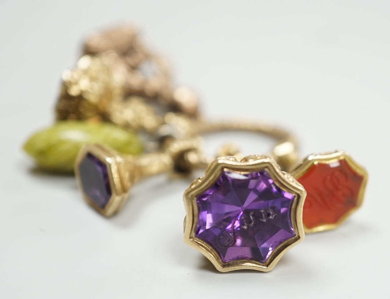 Four Victorian assorted yellow metal and gem set fob seals, including two amethyst(one carved with initials), one citrine and one carnelian (carved with monogram), together with a stone? charm and a gold plate mounted ci